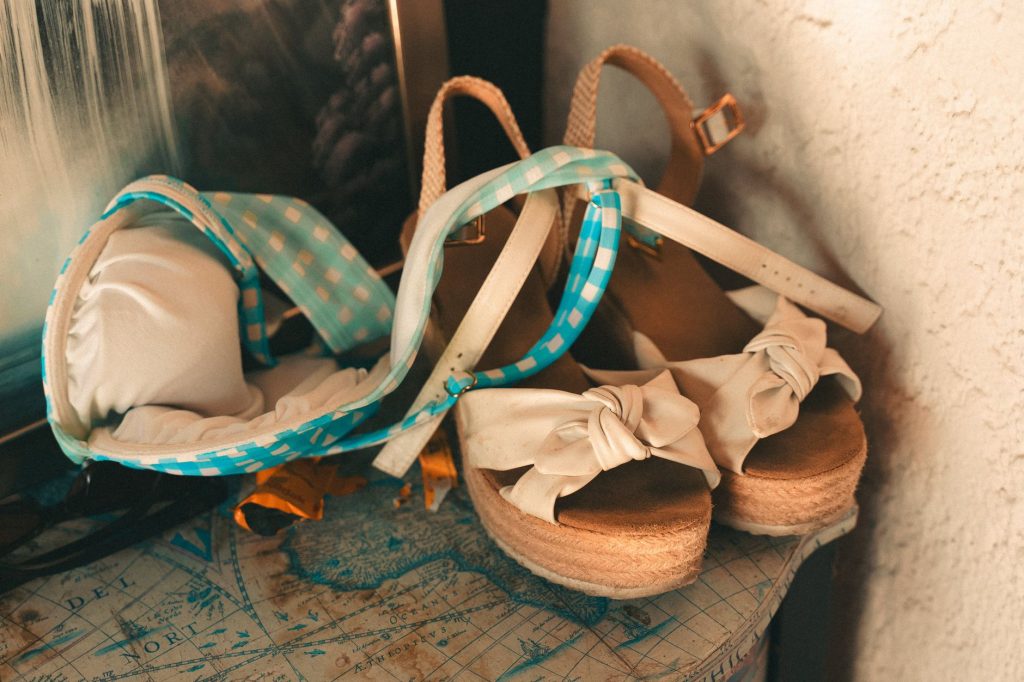 Sandales compensées à semelle en corde et nœud beige posées sur une table en bois